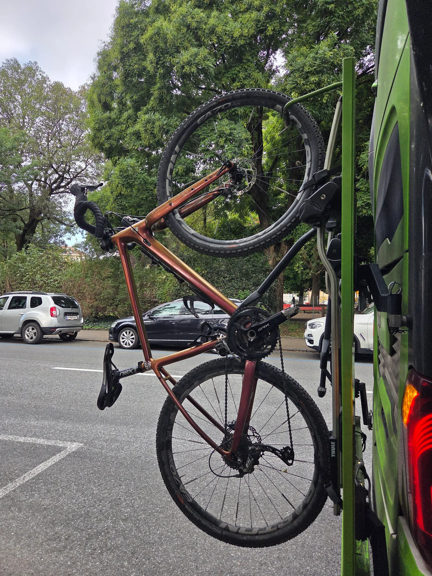 Gravel bike on the rear rack of the green long-distance bus