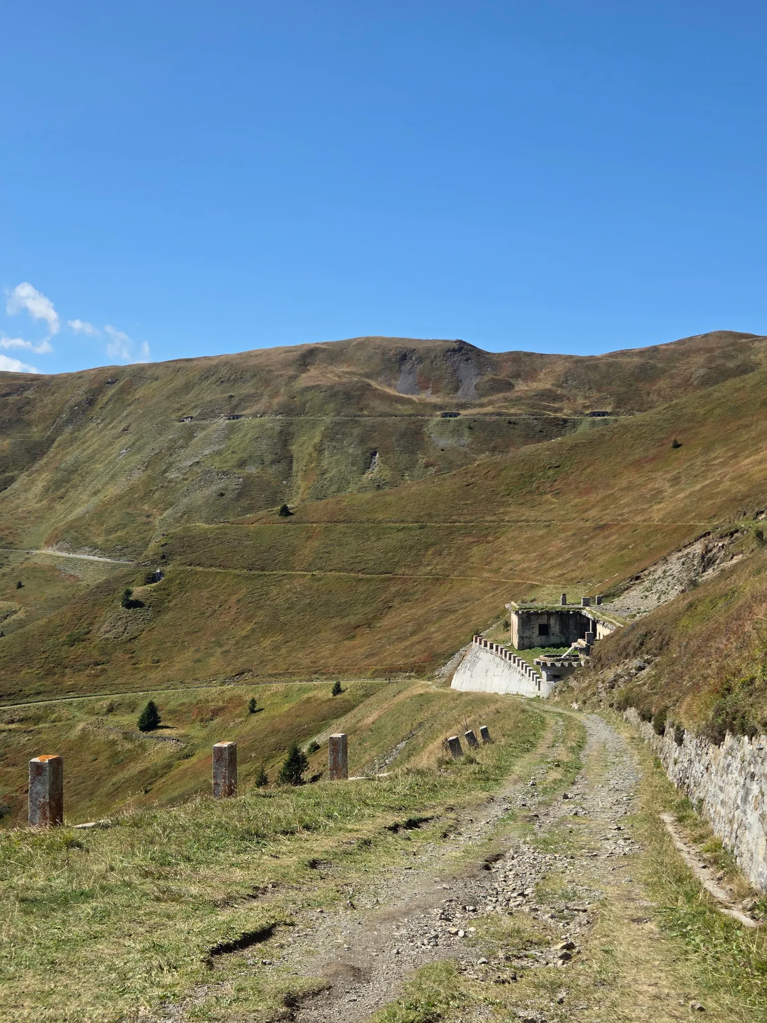 Old military road on the Grenzkammstraße with stone posts and an abandoned concrete building