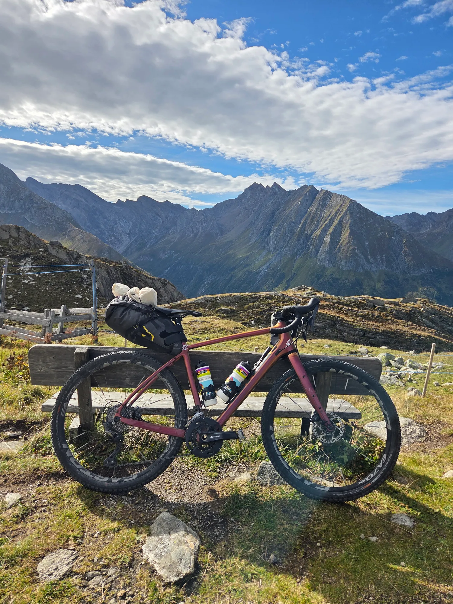 Gravel bike leaning on a wooden bench overlooking the Zillertal mountains