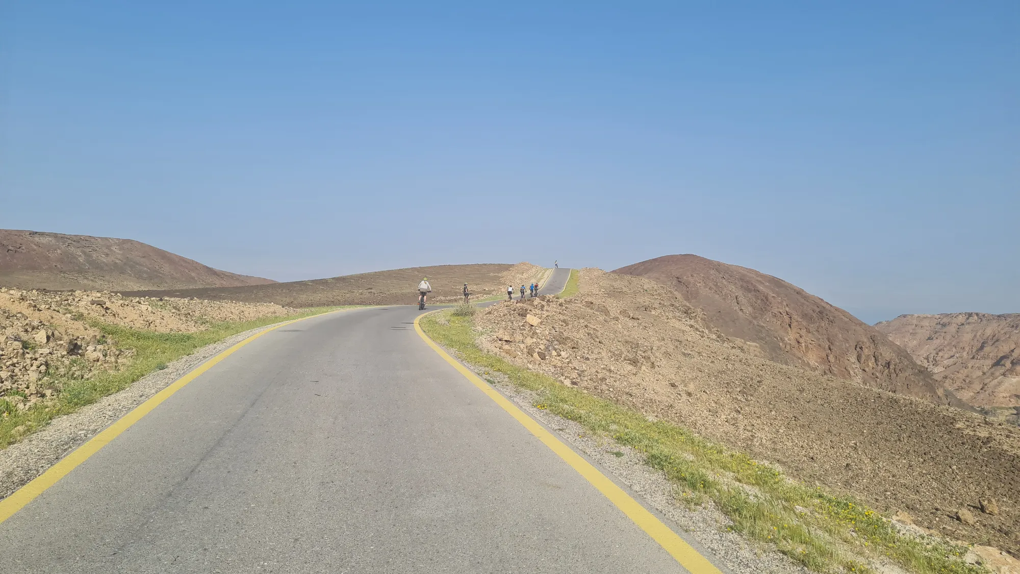 Empty road through barren, yellow-brown hills
