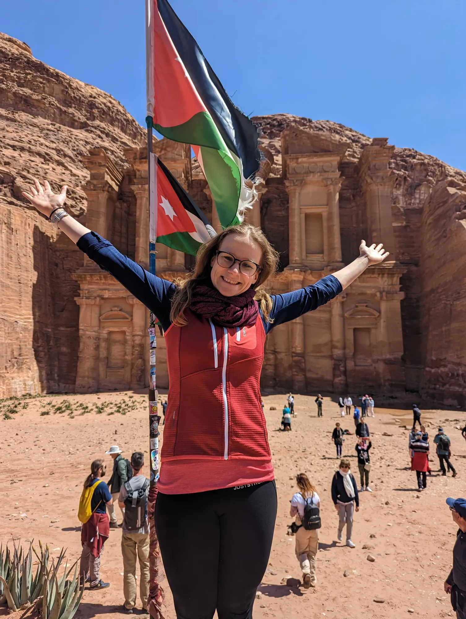 Arms spread wide in front of the Monastery in Petra