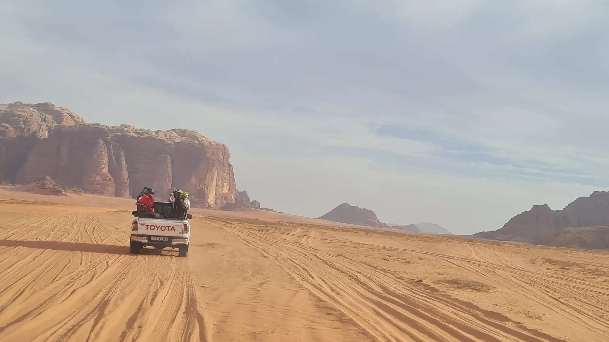 Jeep on sand tracks in front of the rocks of Wadi Rum