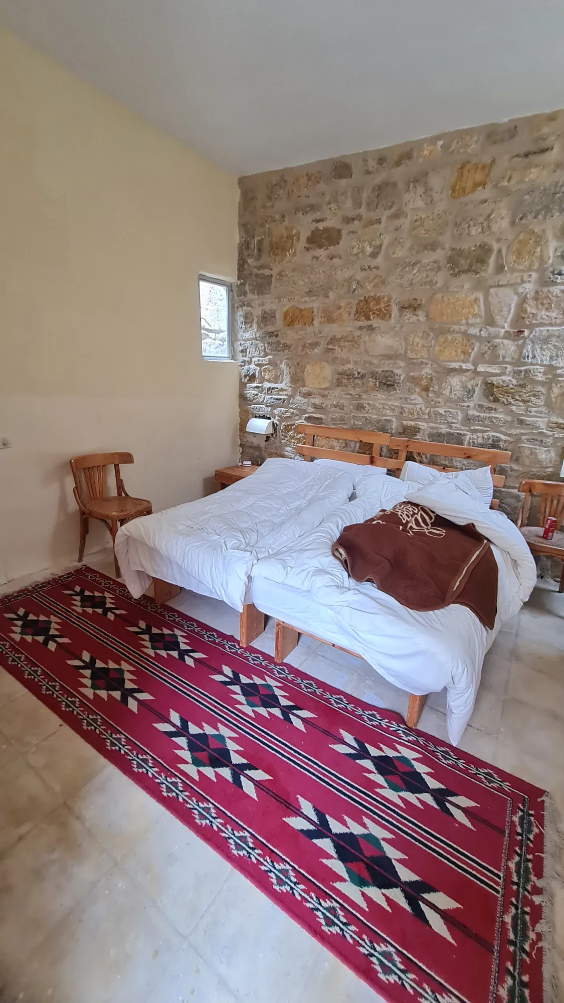 Room with a stone wall and a red rug