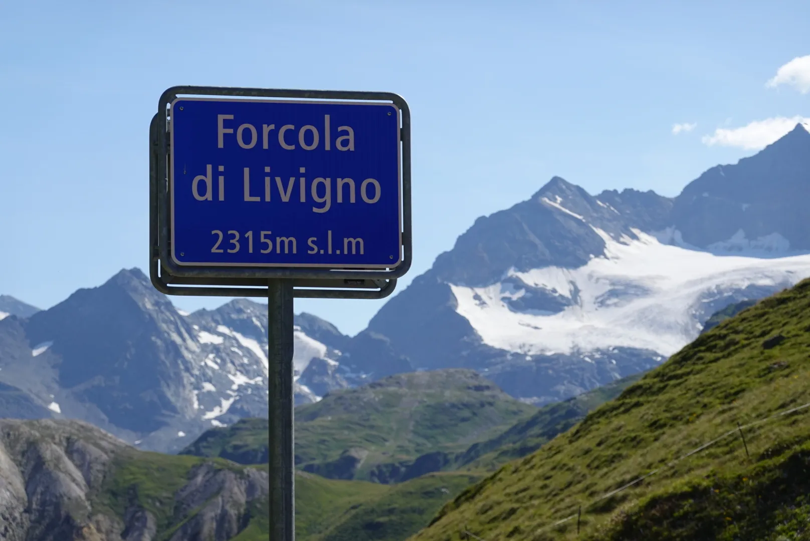 Forcola di Livigno pass sign, 2315 m, in front of glaciers