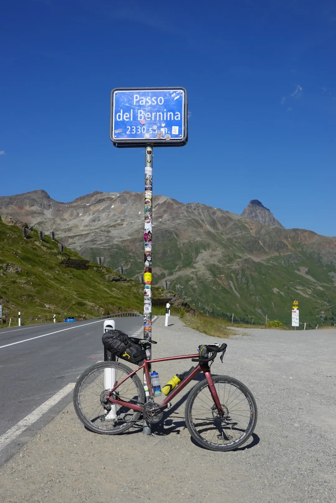 Gravel bike at the Passo del Bernina pass sign