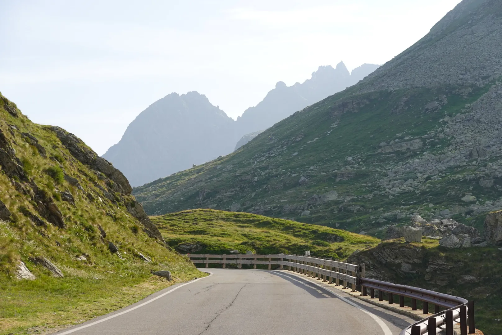 Pass road winding through green slopes up to the Splügen Pass
