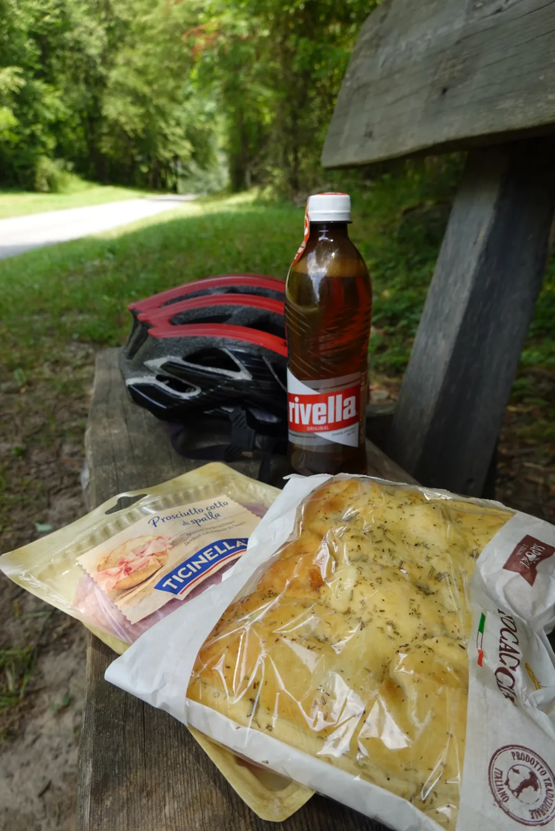 Picnic on a wooden bench: Rivella, helmet and snacks
