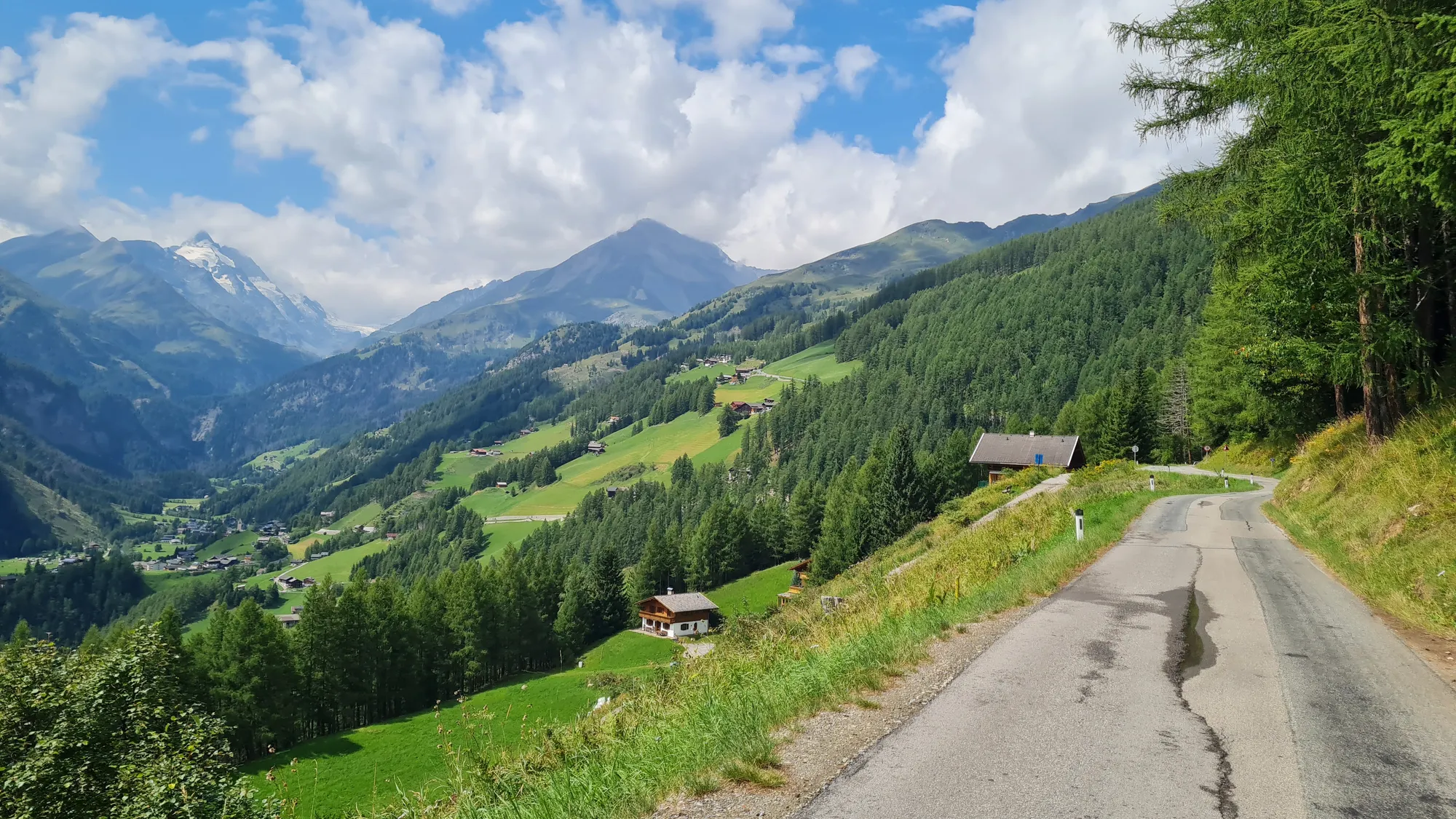 Narrow road looking down into the green valley and towards the Hohe Tauern