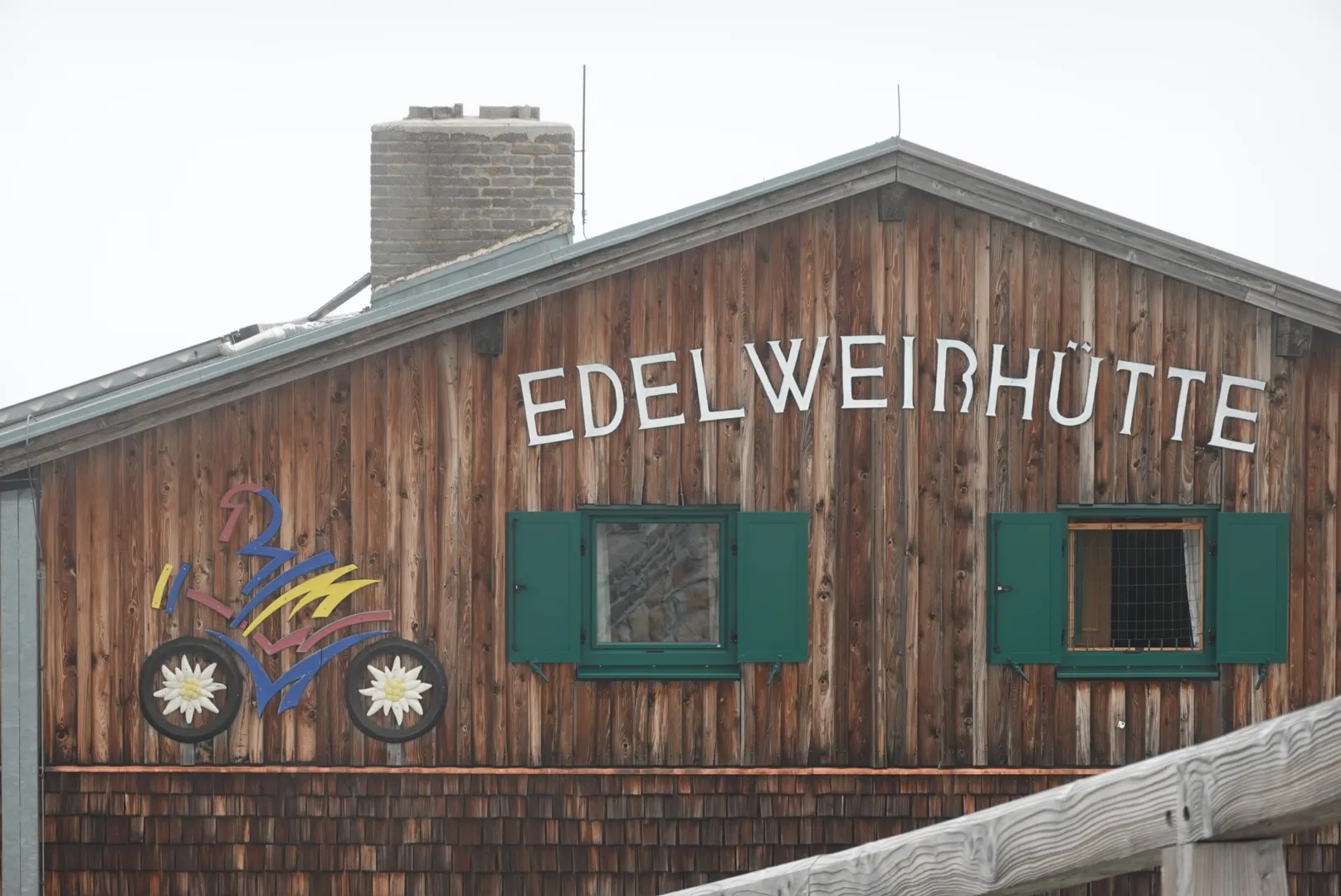 Wooden façade of the Edelweißhütte with green shutters
