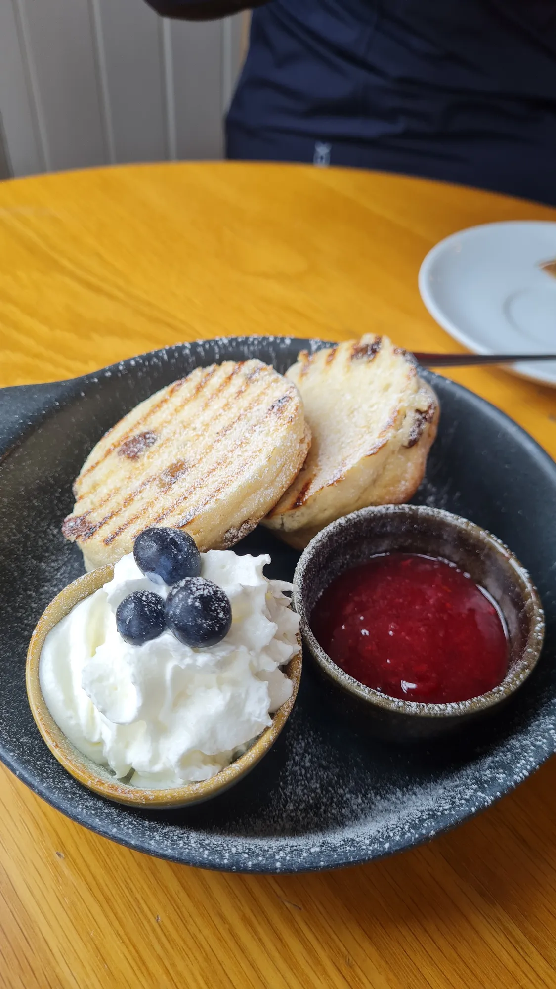 Fruit scone with cream, blueberries and jam