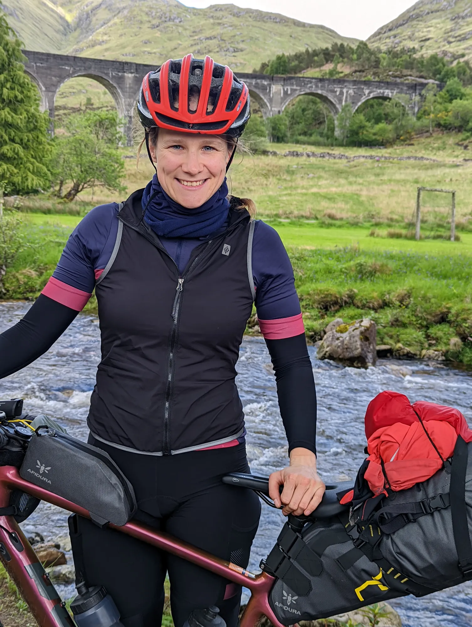 Carla laughing in her helmet in front of the Glenfinnan Viaduct