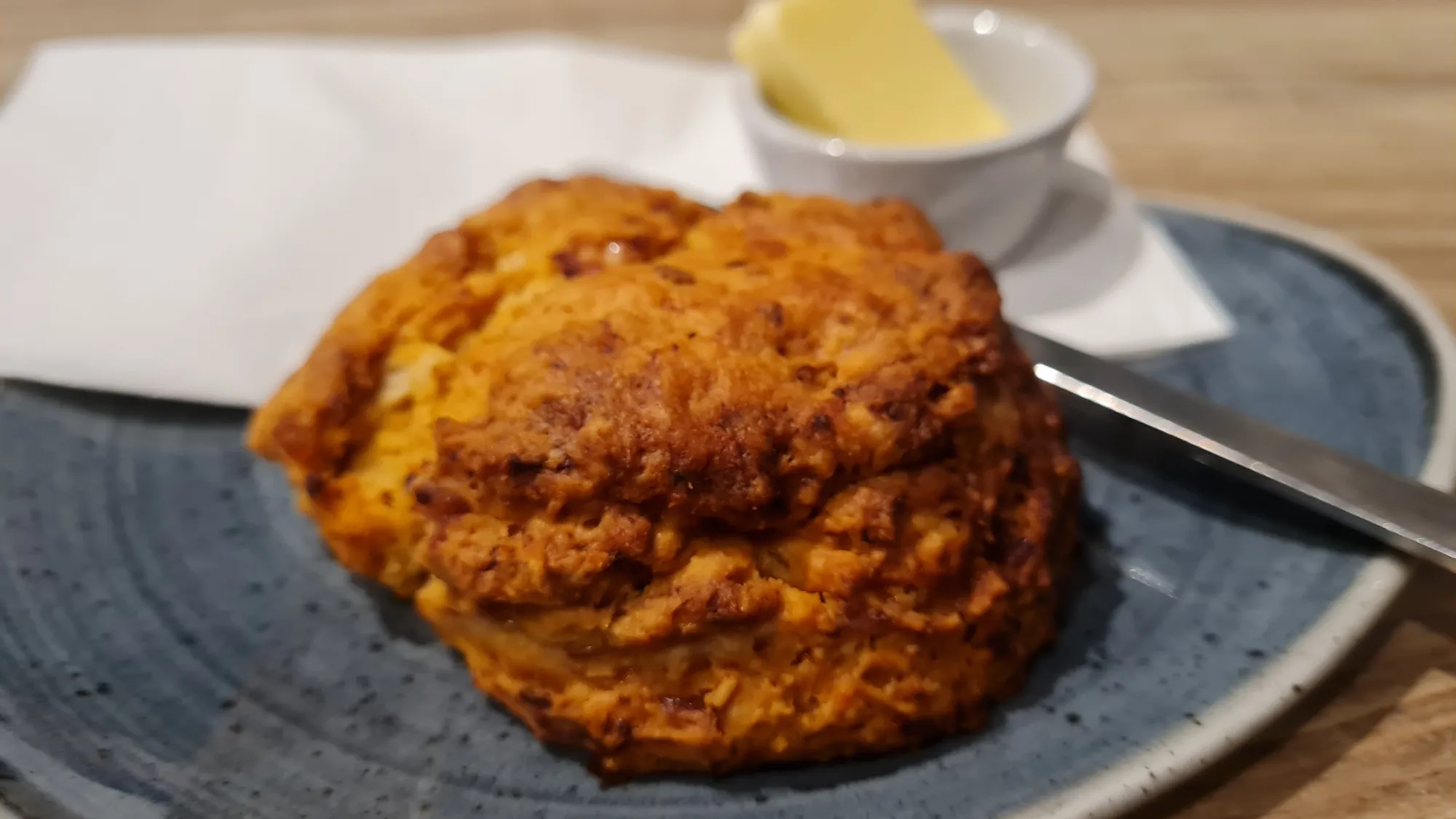 A scone with butter on a plate