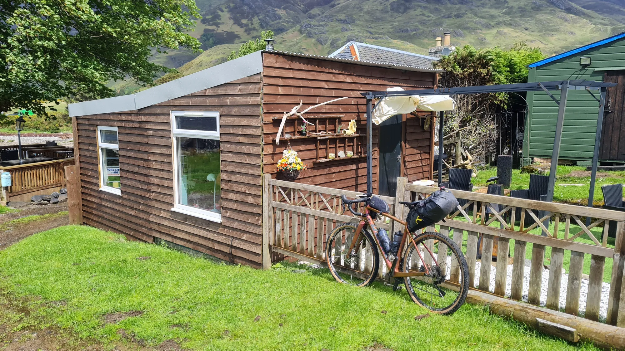 Gravel bike against the fence of the little wooden hut in Arnisdale