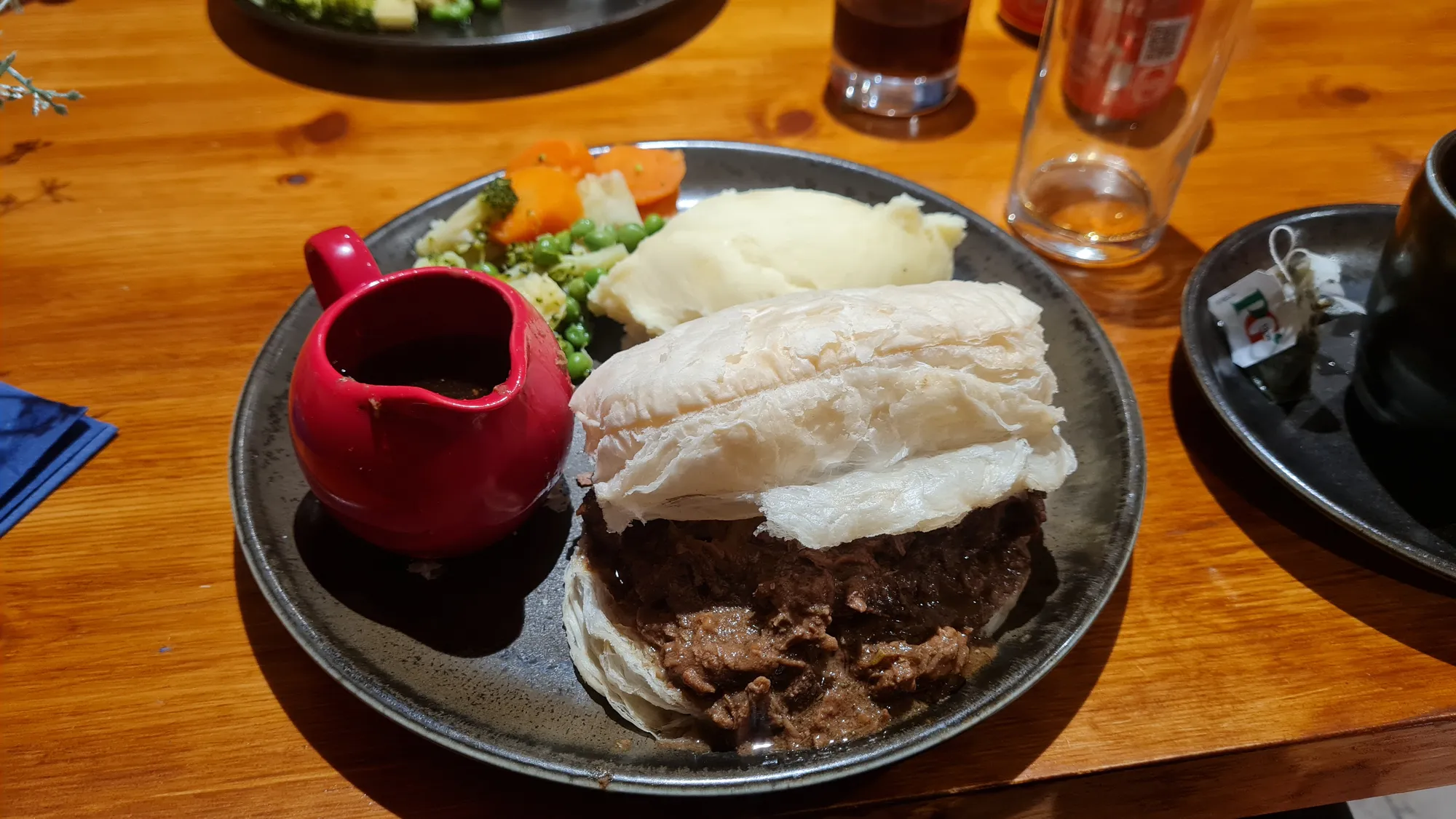 Pie with mashed potatoes, vegetables and a small jug of gravy