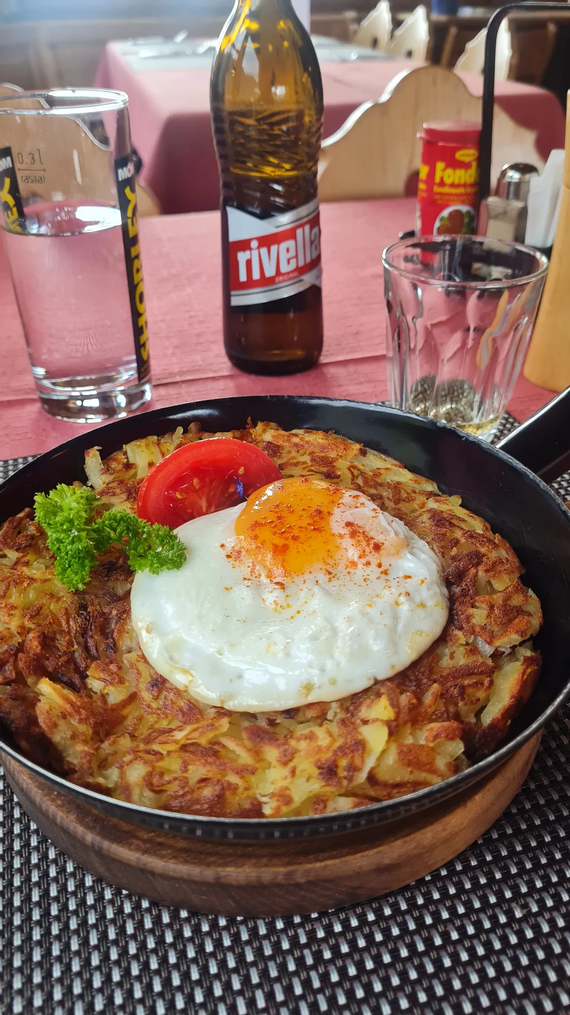 Rösti with a fried egg and a bottle of Rivella