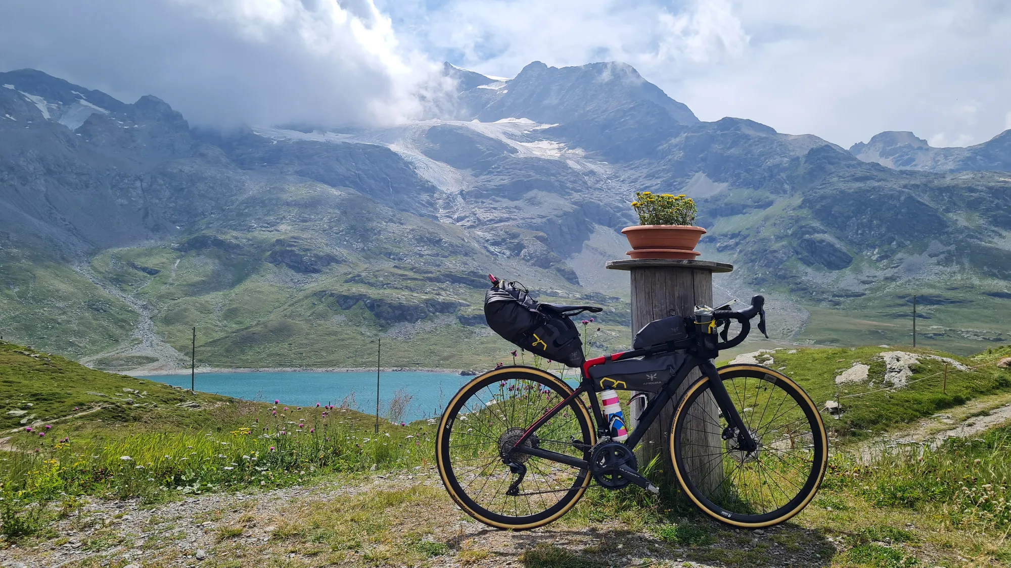 Bike in front of the turquoise Lago Bianco and the glaciers on the Bernina Pass