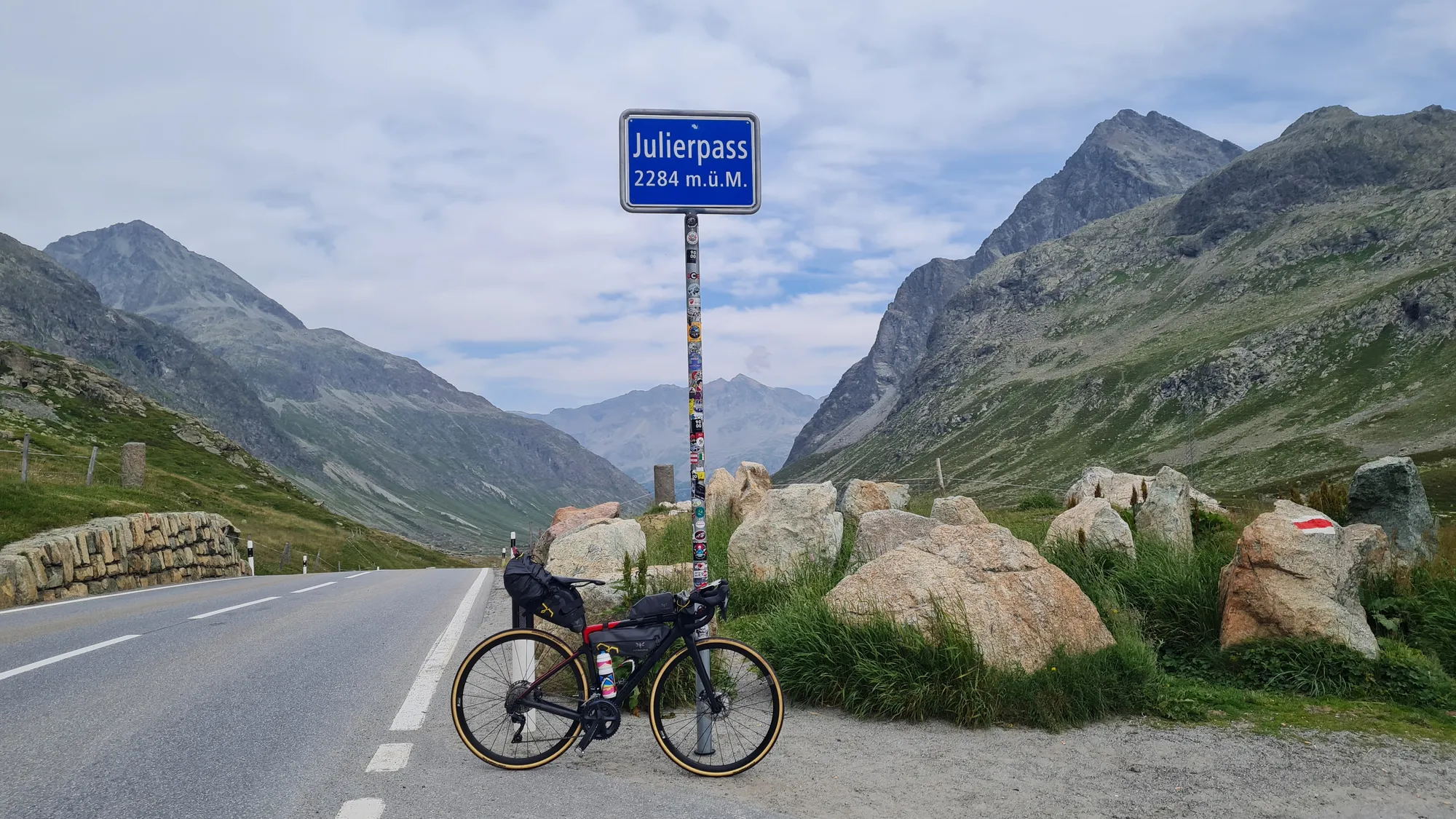 Bike at the Julierpass sign, 2284 m, between boulders