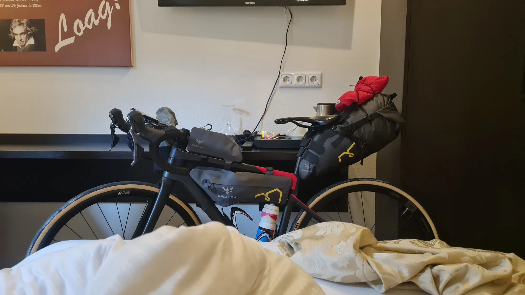 Loaded bike in the room, a rumpled duvet in front of it