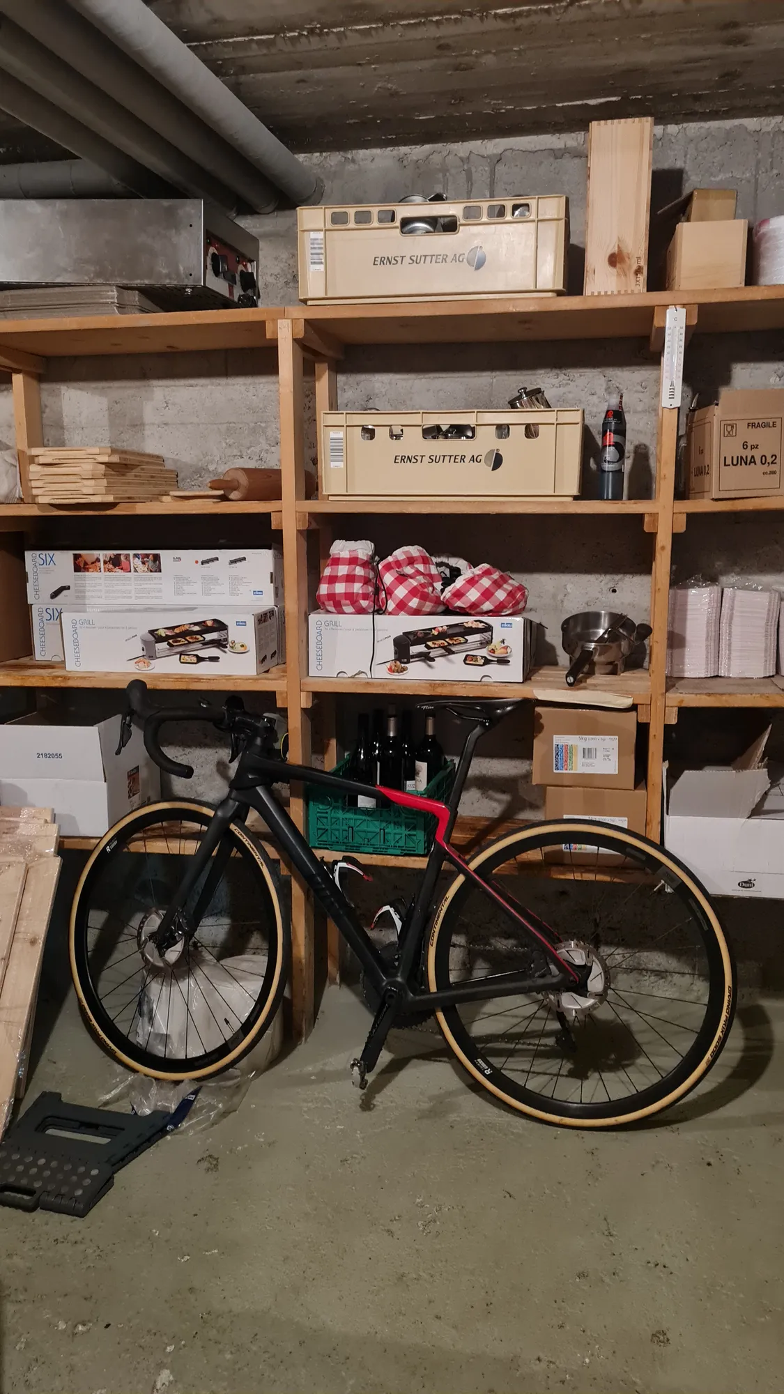 Bike in the hospice storeroom between shelves and a raclette machine